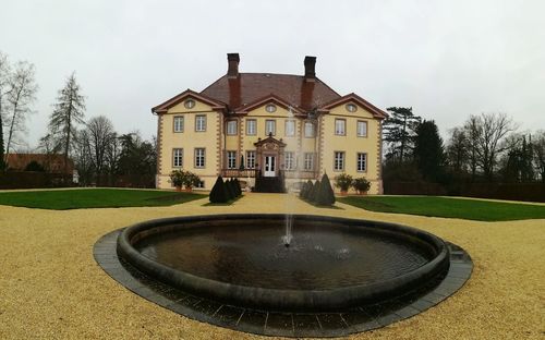 View of swimming pool by house against sky