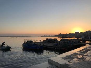 Boats in sea at sunset