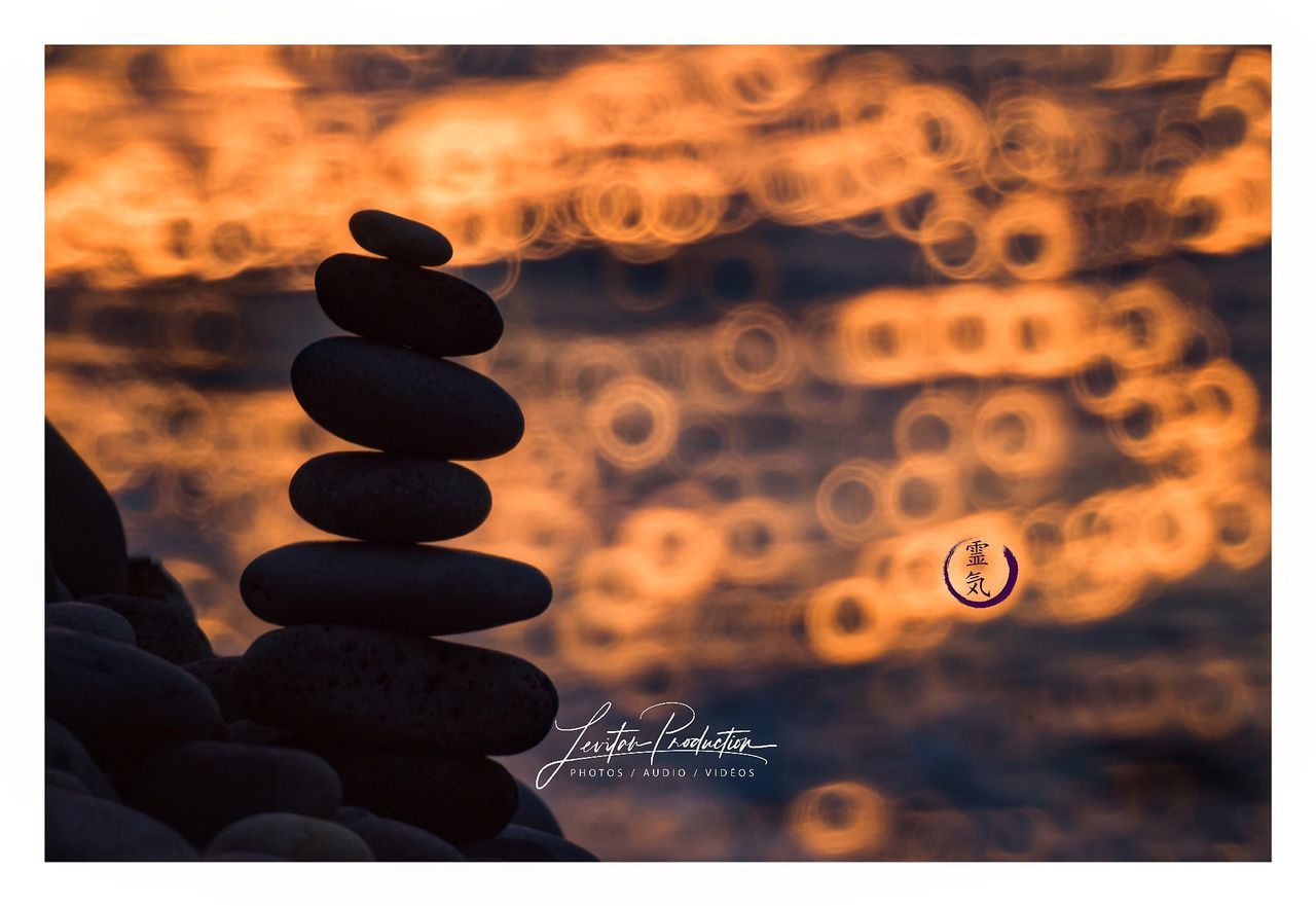 auto post production filter, transfer print, no people, focus on foreground, nature, sky, sunset, outdoors, close-up, orange color, stack, text, communication, rock, number, stone - object, belief, selective focus, pebble