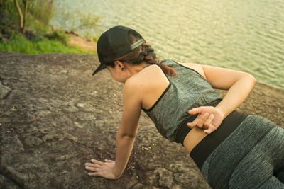 Full length of young woman on rock at shore