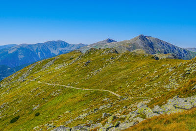 Scenic view of mountains against clear blue sky