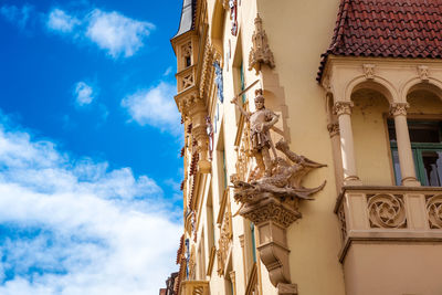 Low angle view of statues on building against sky