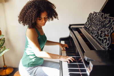 Midsection of woman playing piano