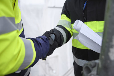 Engineers having handshake, mid section