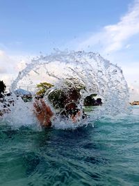 People swimming in sea against sky