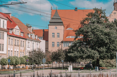 Low angle view of trees and buildings against sky