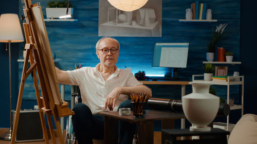 Portrait of senior man sitting on table