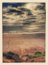 Scenic view of beach against dramatic sky