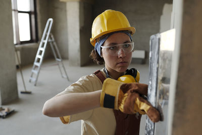 Construction worker wearing hardhat and working at site