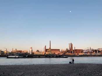 Sea by buildings against clear sky