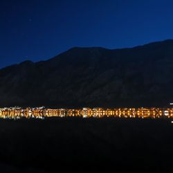 Illuminated city against clear sky at night