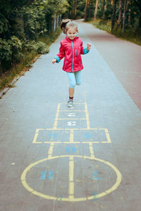 Active little girl playing hopscotch on playground outdoors. jumping for joy. children outdoor