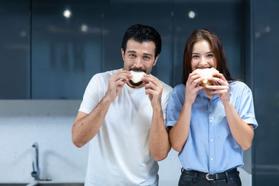 Portrait of young couple holding ice cream