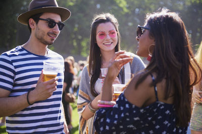 Friends holding drinks while talking in party