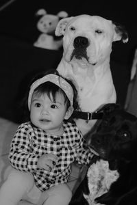 Cute baby girl with dogs sitting at home