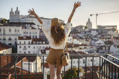 Rear view of woman standing with cityscape in background