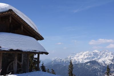 Scenic view of snow covered mountains against blue sky