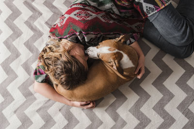 Directly above shot of woman and dog sleeping on bed