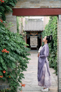 Rear view of woman standing against building