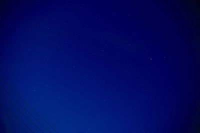 Low angle view of moon against blue sky at night