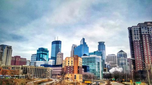 Buildings in city against cloudy sky