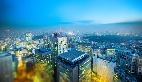 High angle view of illuminated city buildings against sky