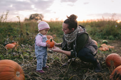 Side view of mother and daughter on field