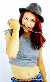 Portrait of young woman standing against white background