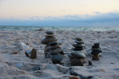 Pebbles on beach against sky during sunset