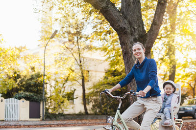 Happy man riding bicycle on autumn leaves