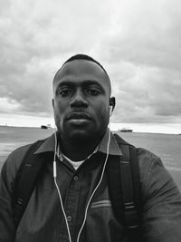 Portrait of man standing by sea against sky