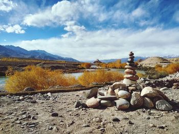 Stack of rocks on land against sky
