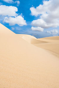 Sand dunes in desert against sky