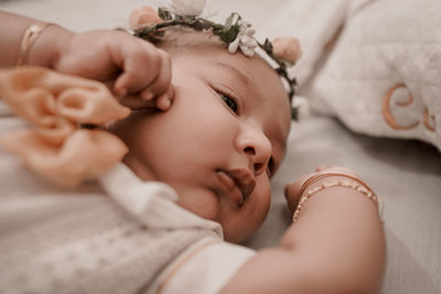 Close-up of baby girl lying on bed