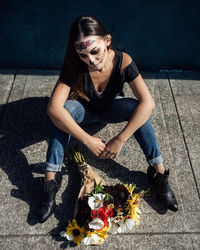 Portrait of young woman sitting on wall