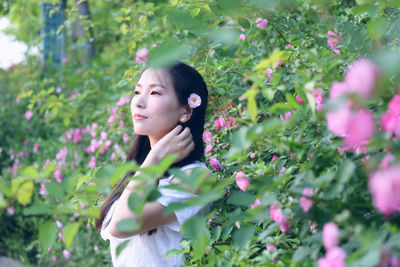 Portrait of woman holding pink flower