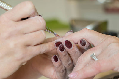 Close-up of hand giving manicure of customer
