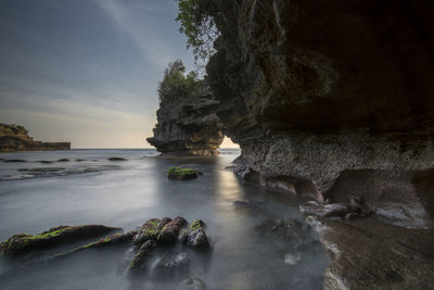 Scenic view of rocks in sea against sky