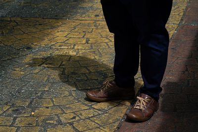 Low section of man standing on footpath