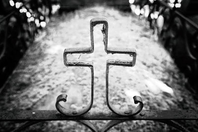 Close-up of cross on fence