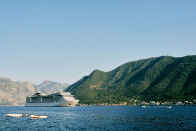 Scenic view of sea and mountains against clear blue sky