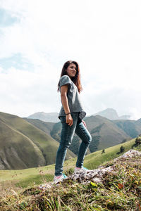 Low angle view of woman looking away while standing against sky