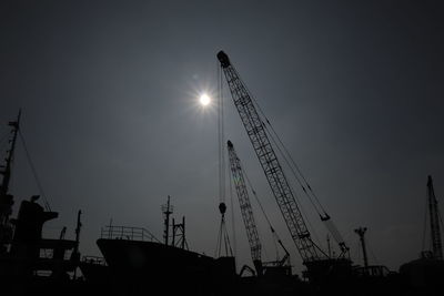 Low angle view of silhouette cranes against sky during the large-scale of social distancing