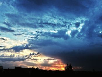 Low angle view of silhouette buildings against dramatic sky