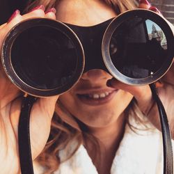 Portrait of woman looking through binoculars