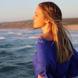 Side view of young woman standing on beach