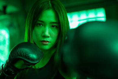 Portrait of woman boxing at gym