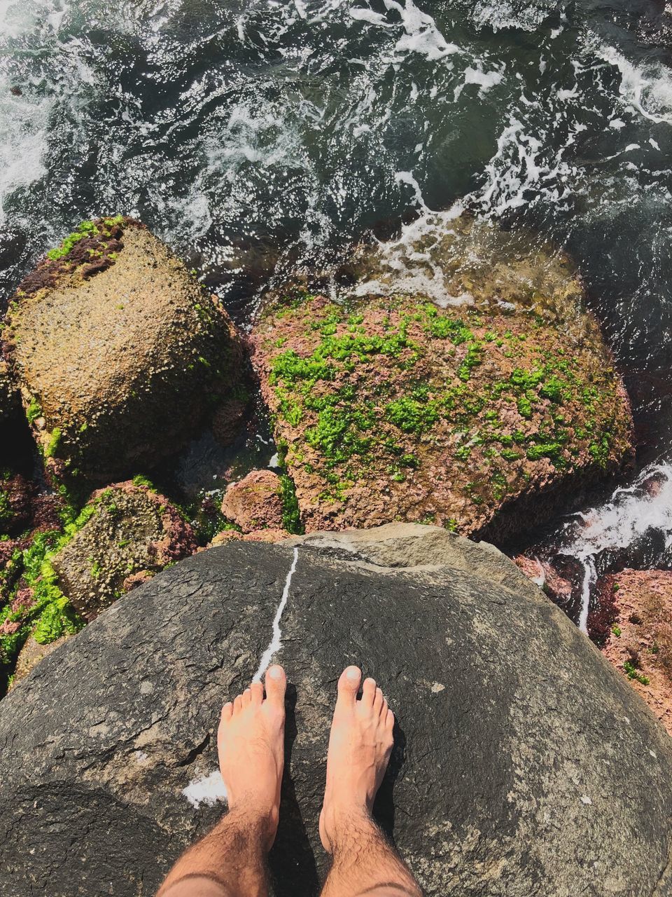 LOW SECTION OF MAN LEGS BY WATER