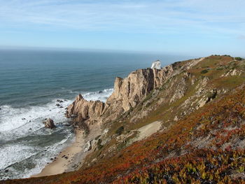 Scenic view of sea and mountains against sky