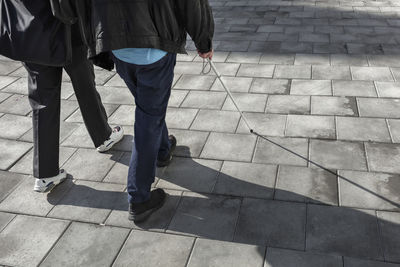 Couple with white cane walking in street